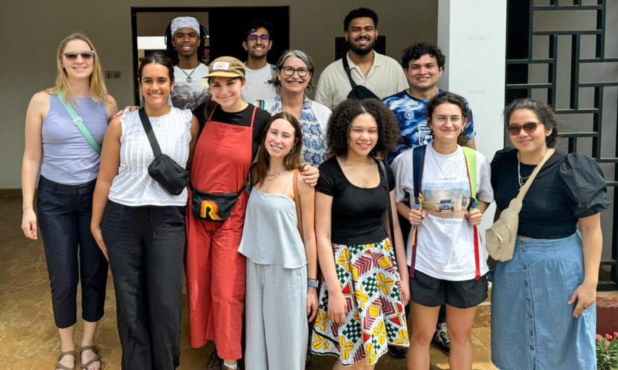 a group of 10 students and 2 faculty smiling